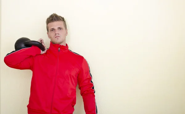 Serious young man (personal trainer or athlete) in tracksuit