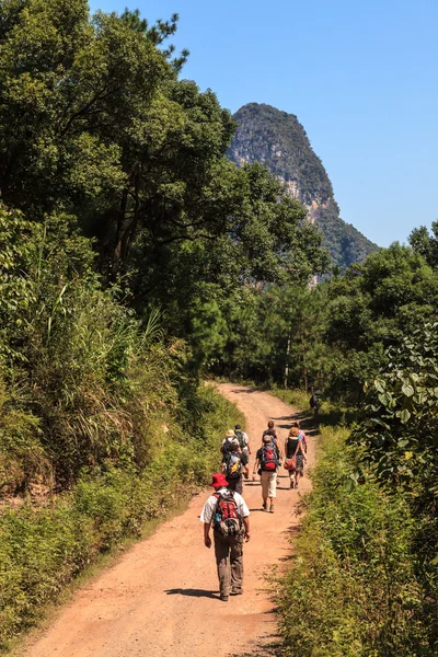 Group of walking through limestone rock valley