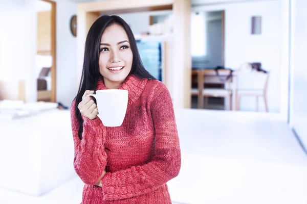 Smiling winter woman holding hot coffee