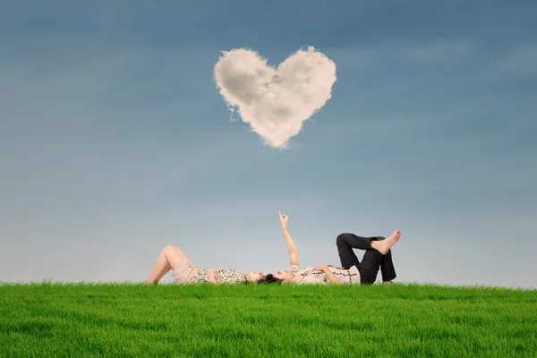 Couple enjoy holiday under heart cloud in park