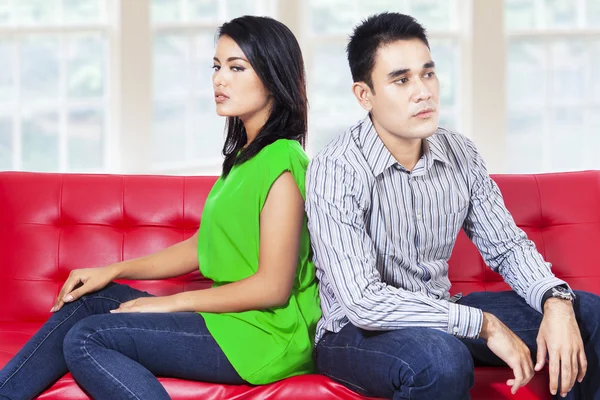 Young couple sitting on the couch after a fight
