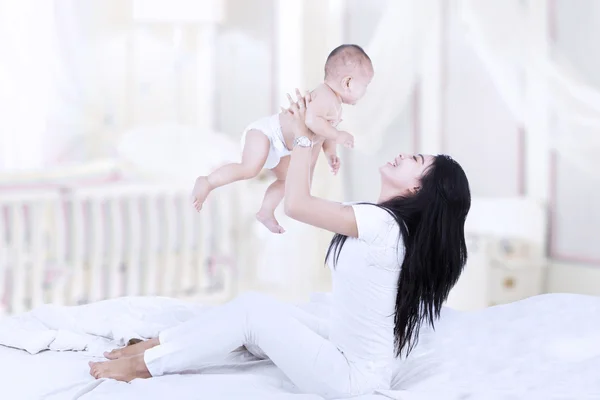 Asian mom lifting a baby