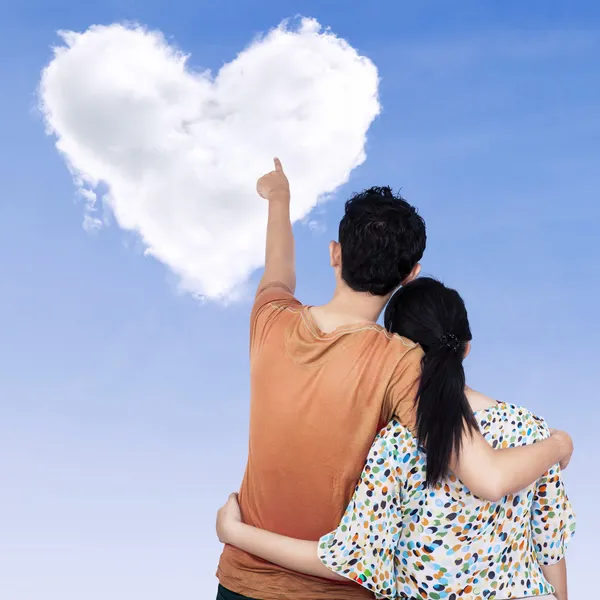 Young couple pointing at heart