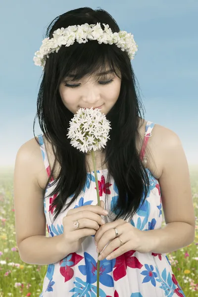 Attractive woman is smelling flower