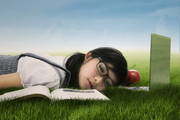 Cute student sleeping on the grass