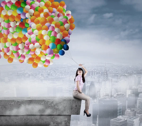 Businesswoman holding a bunch of balloons