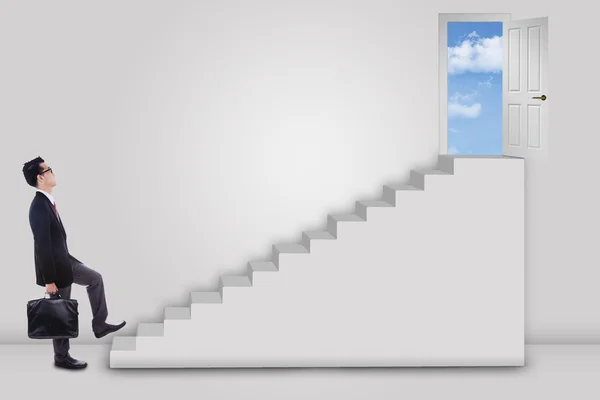 Businessman stepping up ladder to success door