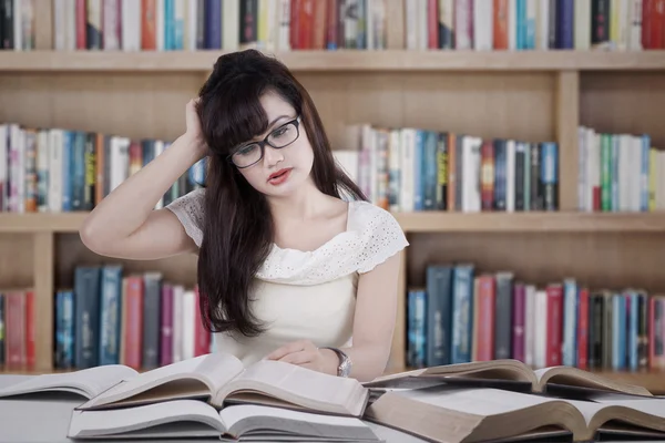 Confused student reading many books 1