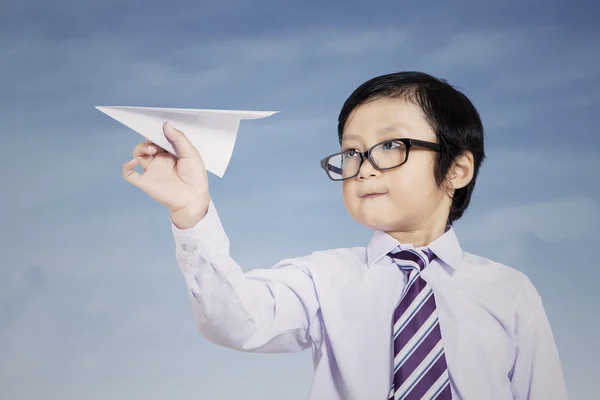 Business kid holding paper airplane outdoor