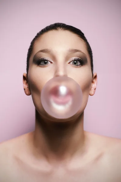Woman blowing a big bubble gum bubble