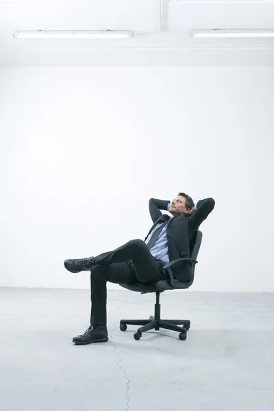Thinkful businessman sitting on office chair