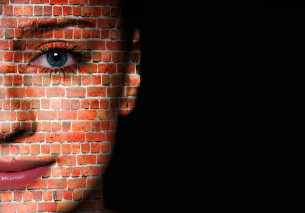 Woman face covered with brick wall pattern over black background