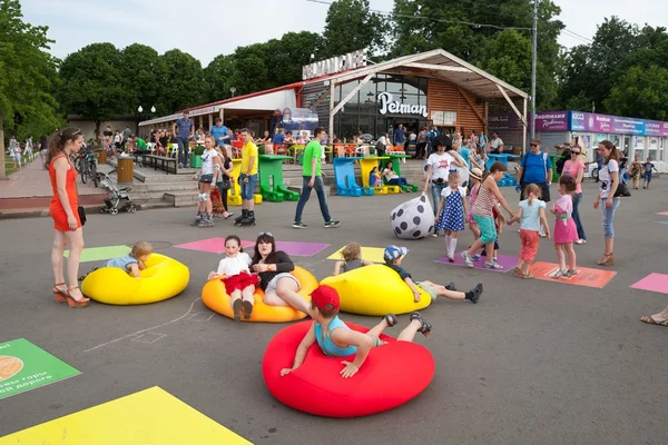 Children and adults playing and lying on inflatable mattresses