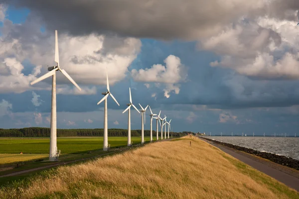 Dutch Windturbines and a cloudscape in the last sunlight of a su