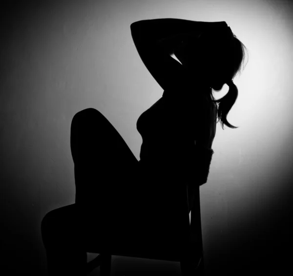 Sad woman sitting alone in a empty room - black and white