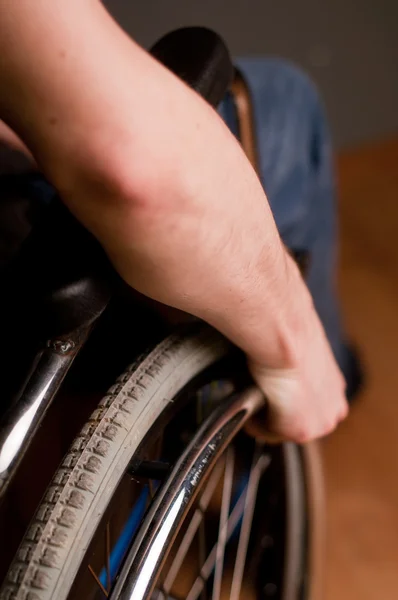Close-up of male hand on wheel of wheelchair