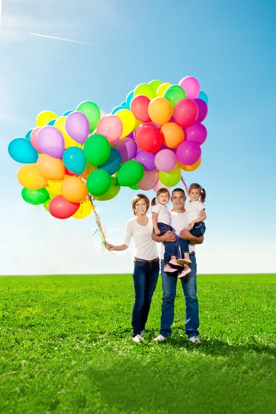 Happy family holding colorful balloons. Mom, ded and two daughte