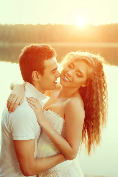 Loving couple hugging on the lake. Beauty young woman and man in