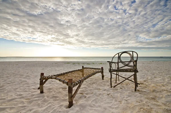Bamboo Chair and Camp Bed Sitting on Sandy Beach