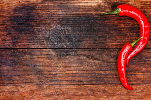 Red peppers on wooden table copy space