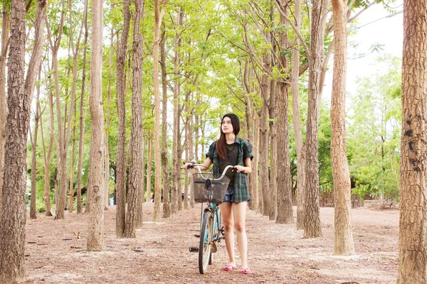 Girl with bicycle in the forest