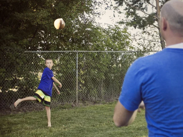 Boy Playing Catch with Dad in the yard