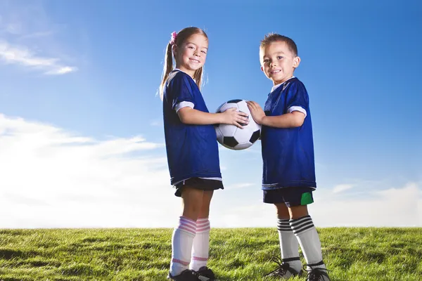 Youth Soccer players smiling together on a grass field