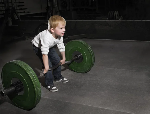 Determined Young Boy trying to lift Heavy weights