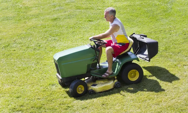 Middle-Aged Man Mowing lawn on riding mower