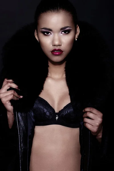 Glamor closeup portrait of beautiful sexy black young woman model with bright makeup with perfect clean with red lips in fur coat