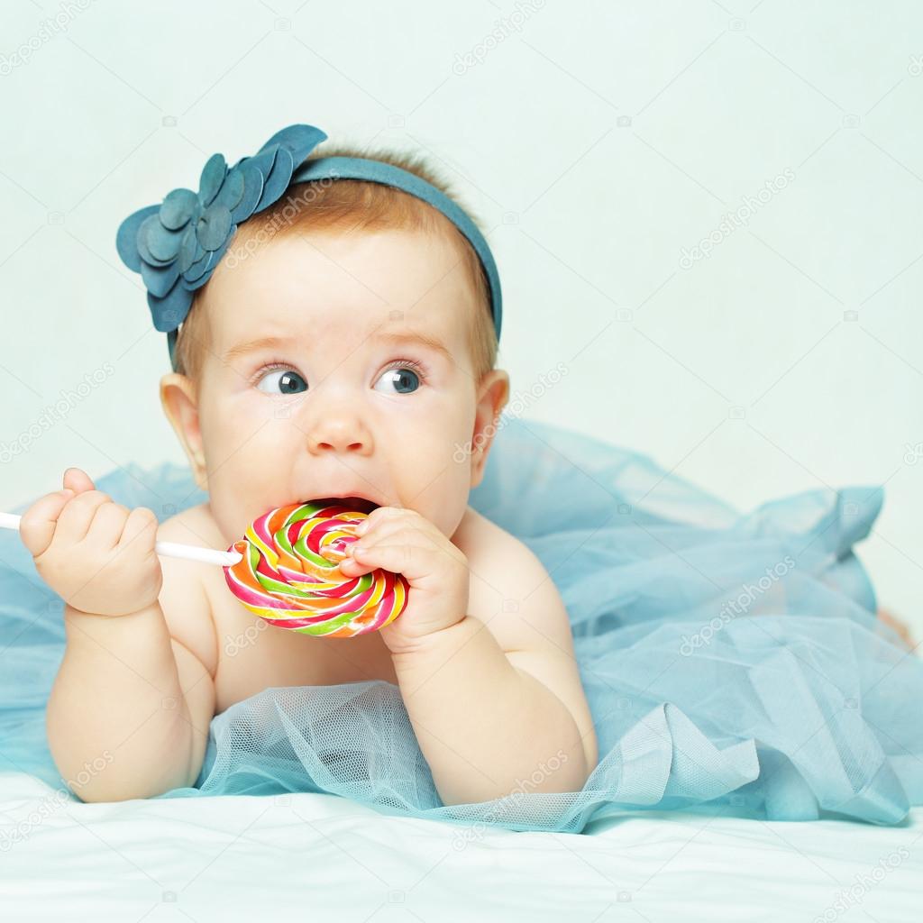 Baby girl eating lollipop — Stock Photo © MillaFedotova 35672995