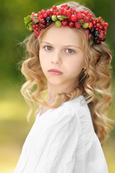 Portrait of a beautiful little girl with berries