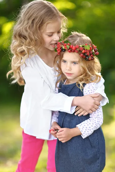 Portrait of two little sisters with berries