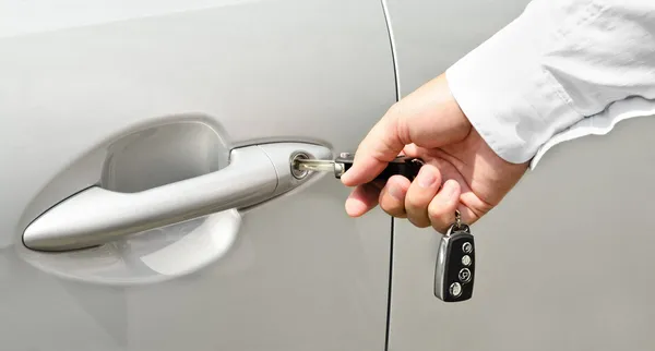 Male hand with key opening car door