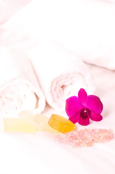 Holiday spa concept with exotic orchid flower on bed
