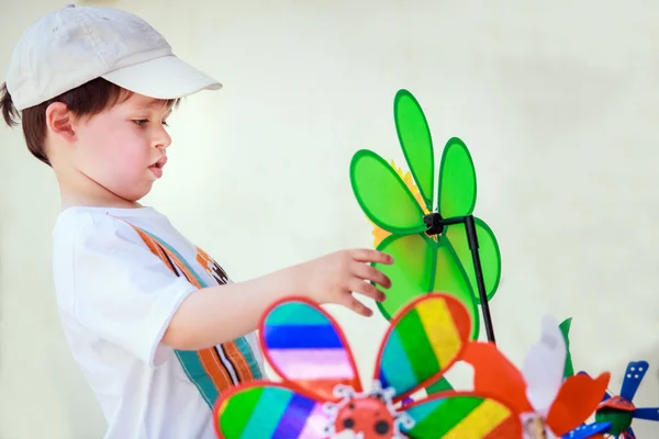 Cute little boy with windmill toys outdoors