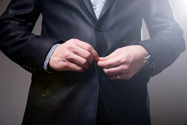 Business man tidy up his suit's button, makes a neat image
