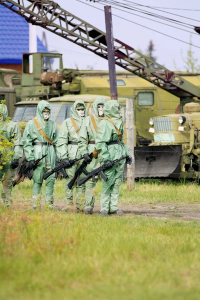 A group of soldiers with guns in their masks and protective clot