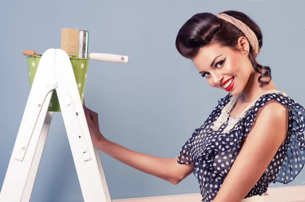 Beauty pinup girl with equipment for painting