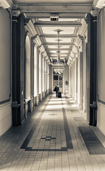 Woman tourist walk on retro railway station corridor