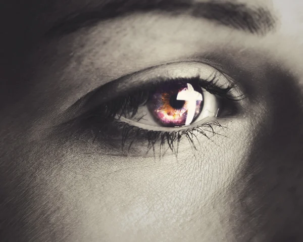 A woman\'s eye with a cross reflection