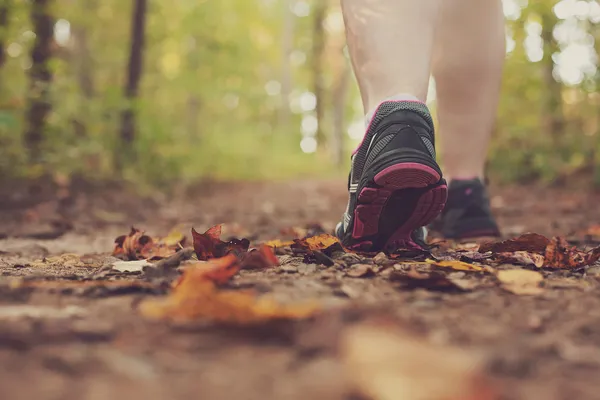 Woman walking through forest.