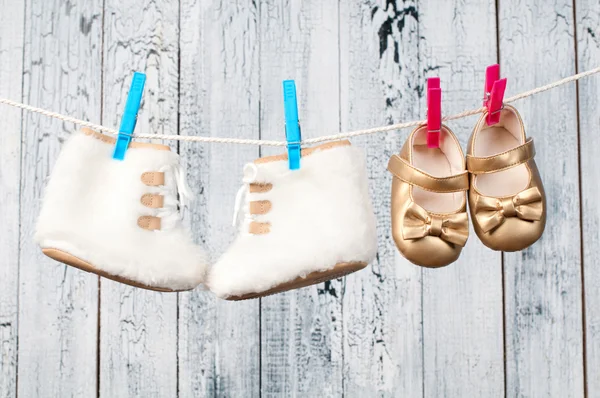 Children\'s boots hanging on a clothesline.