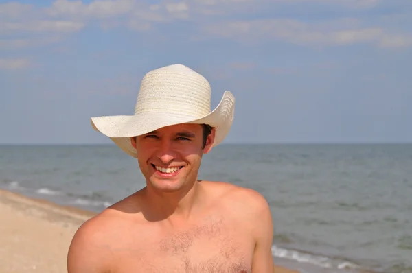A man in a straw hat on the beach