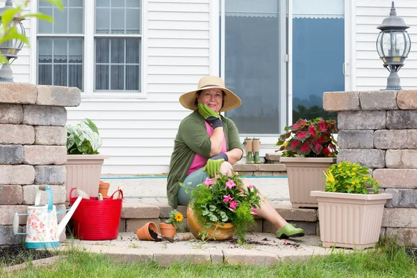 Grandmother potting up plants on her patio