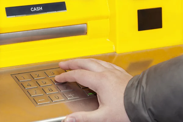 Man\'s hand near the cash machine on the pin code