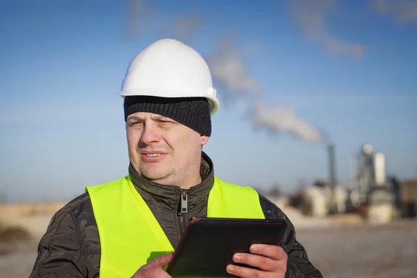 Engineer with tablet PC near the factory