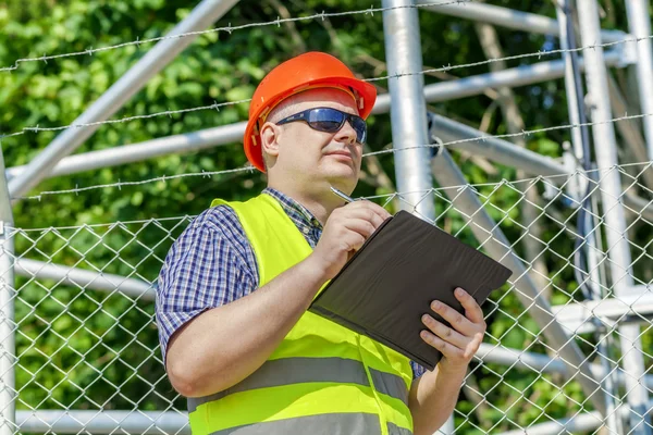 Worker with folder near the fence