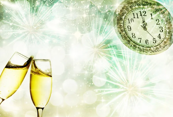 Glasses with champagne and clock close to midnight