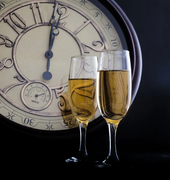 New Year\'s at midnight with champagne glasses and clock